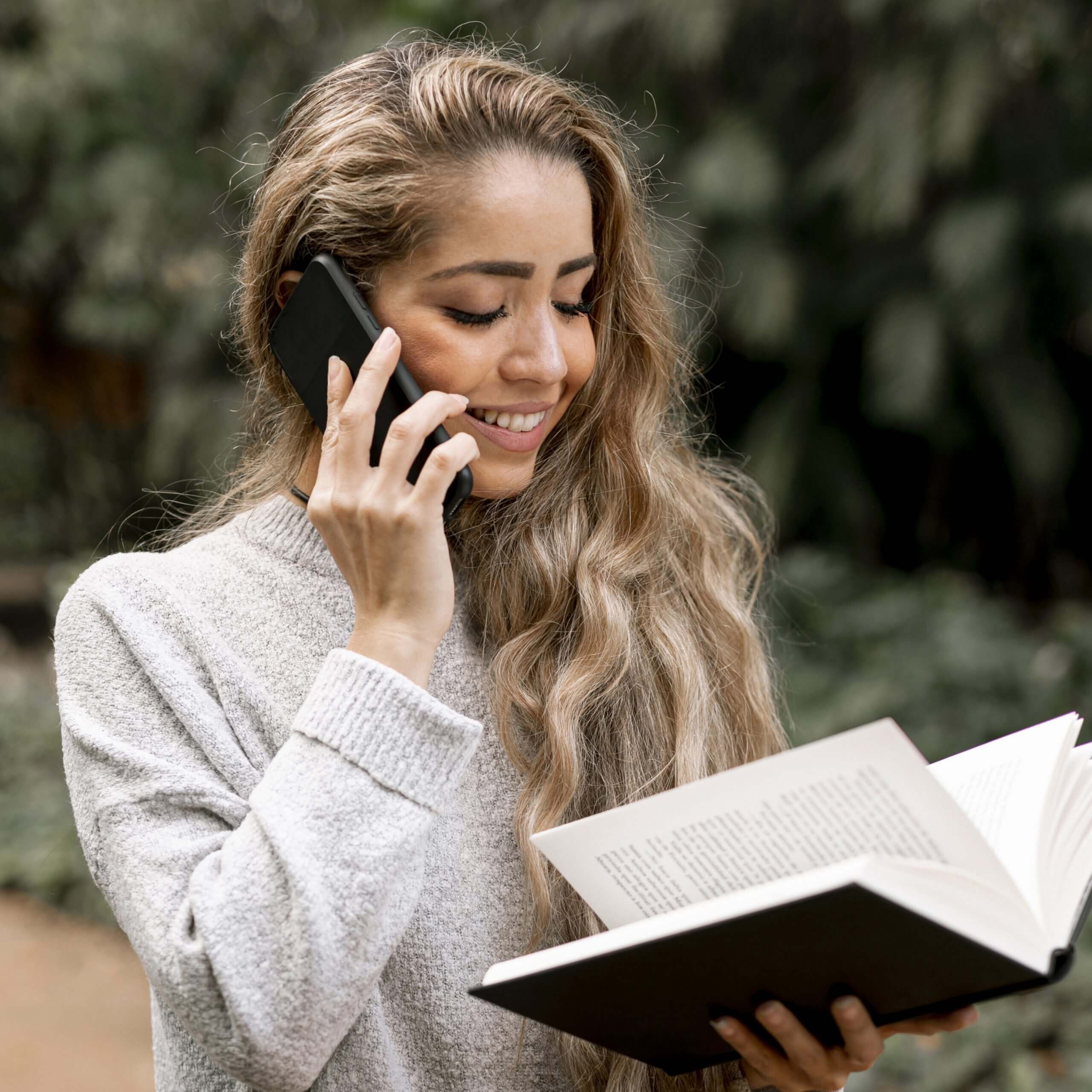 Femme parlant au téléphone lisant un livre